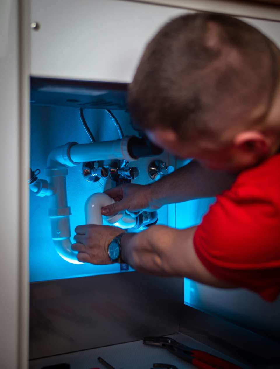 Hombre reparando tuberías iluminadas